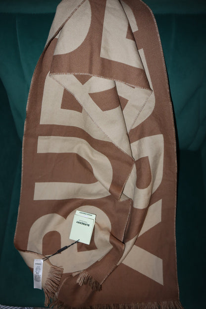 Brown and beige Burberry scarf with brand logo on a green surface